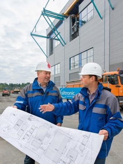 Siltronic Projektmanager Johann Sperl (rechts) und Wacker Chemie Projektleiter Gerhard Ofenmacher vor der neuen Siltronic Ziehhalle in Freiberg.