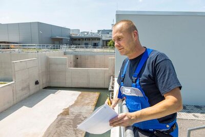 Der Mitarbeiter der Leitzentrale, Kai Wazlawik, kontrolliert den Wasserablauf am neuen Regenrückhaltebecken der Siltronic AG in Freiberg.